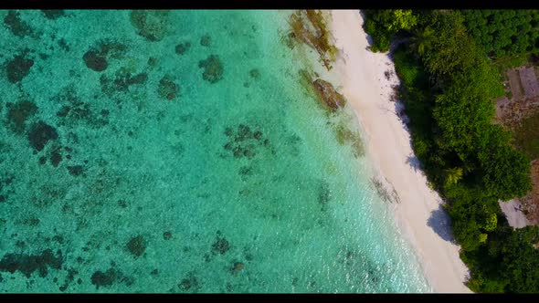 Aerial top down scenery of perfect resort beach adventure by blue lagoon and white sandy background  alt