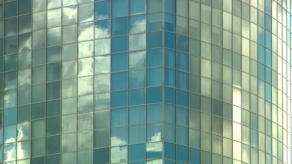 Tall Mirrored Skyscraper Reflects the Clouds Going By in a Timelapse alt