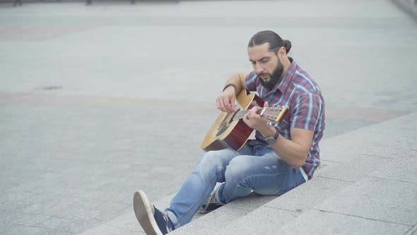 Top Angle View of Serious Musician Performing on Urban City Stairs. Portrait of Handsome Thoughtful alt