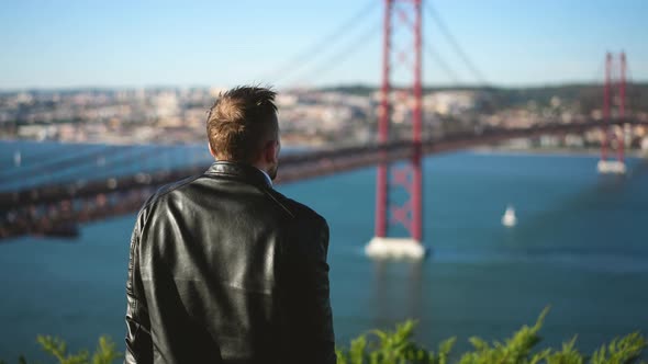 Single Male Traveling Tourist Looks at Lisbon Cityscape and Ponte 25 De Abril