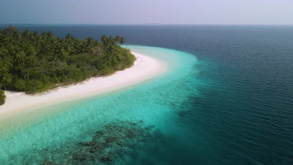 Incredible view of a beautiful Maldivian island with green trees, white sand and turquoise water alt