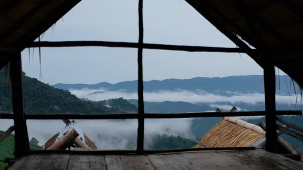 Greenery mountains views and sea of mist through wooden hut window