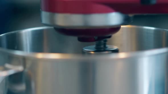 Red Mixer Rotates and Prepares Food in Big Metal Bowl alt