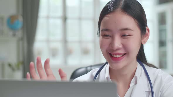 Close Up Asian Female Doctor Communicates With Patient By Video Link on Laptop Computer alt