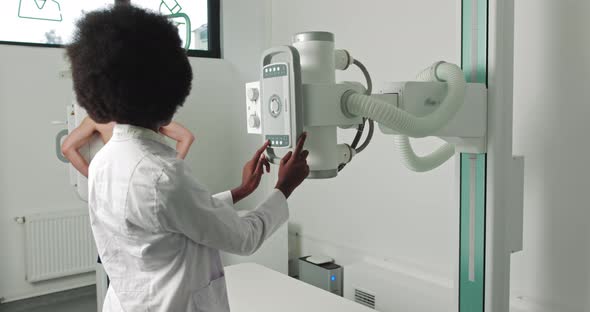 In the Hospital Man Standing Face Against the Wall While Medical Technician alt