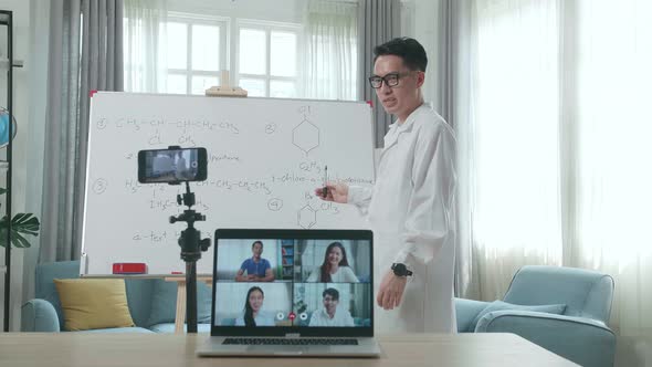 Teacher Shoots Video By Smartphone And Having Video Call On Laptop While Teaching Chemist Online alt