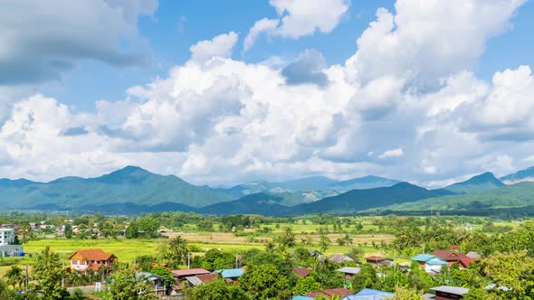 Beautiful rice paddy farming filed and village town at Pua district, Nan, Thailand - time lapse