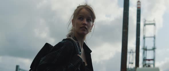 Young woman turning towards camera wearing a backpack alt