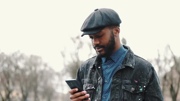 Stylish African Young Man Outside with His Smartphone alt