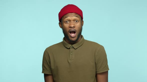 Slow Motion of Attractive African American Man with Beard Wearing Red Beanie and Tshirt Raising
