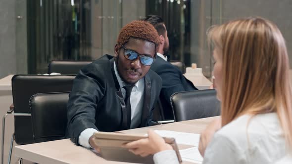 African American manager and his Caucasian colleague sitting on the table