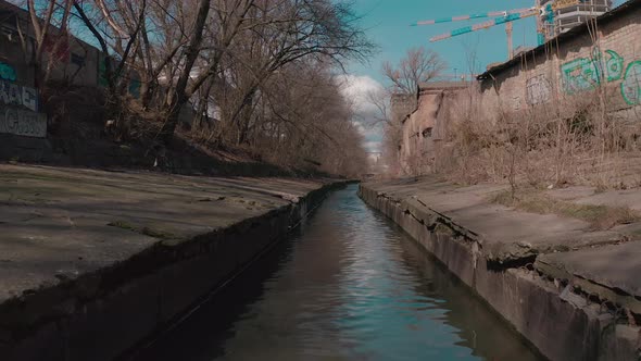 The River Flowing in a Concrete Reservoir in the City alt