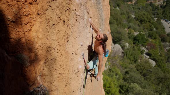 Slow Motion Top View of Strong Handsome Man Rock Climber Climbs on Vertical Cliff By Tough Route alt