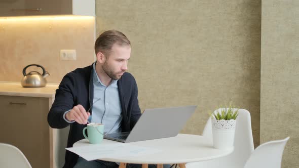 Remote Job. A Man Is Working with Documents on Laptop Remotely at Home. A Business Man Is Using alt