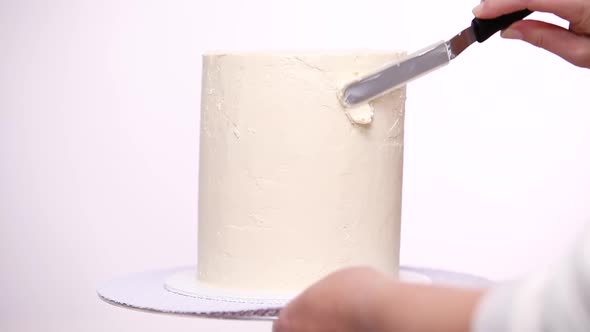 Step by step. Icing tall birthday cake with white buttercream icing. alt