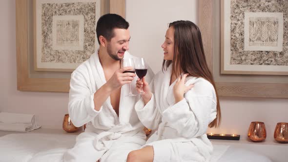 Happy Beautiful Couple Drinking Champagne and Laughing in Spa Center.