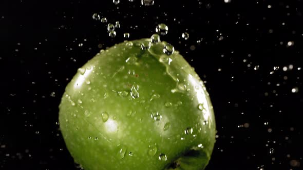 Flying of Green Apple in Black Background in Slow Motion alt