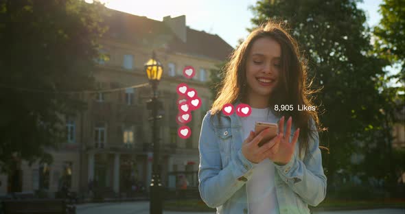 A Cheerful Girl Is Going and Looking Through Her Social Networks alt