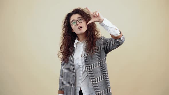 Woman with Beautiful Smile Shows Small Gesture with Her Hand and Smiles Looking at the Room alt