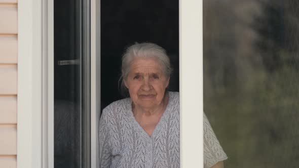 The Old Woman Looks Out of the Window and Smiles.