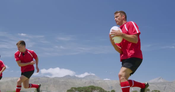Rugby players playing on field alt