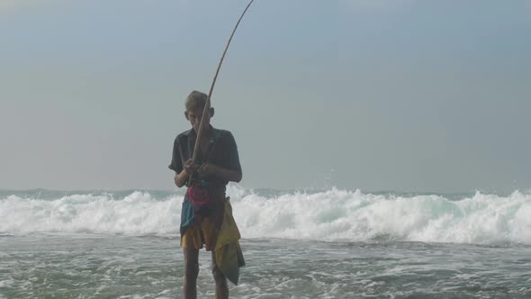 Aged Sinhalese Man with Wooden Fishing Pole at Ocean Slow alt
