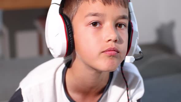 Boy with Headphones Playing a Video Game