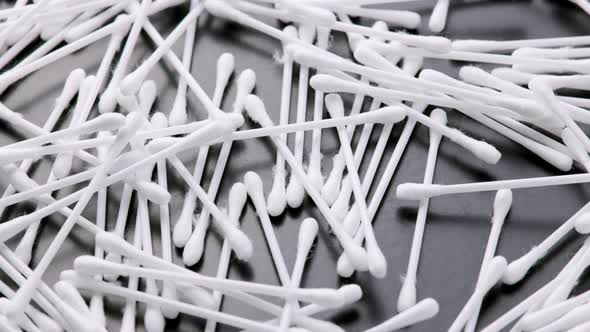 Pile of Qtips or Cottom Buds Slowly Rotating on Black Background alt