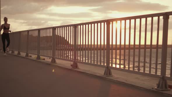 Young Sportswoman Running Along the Promenade alt