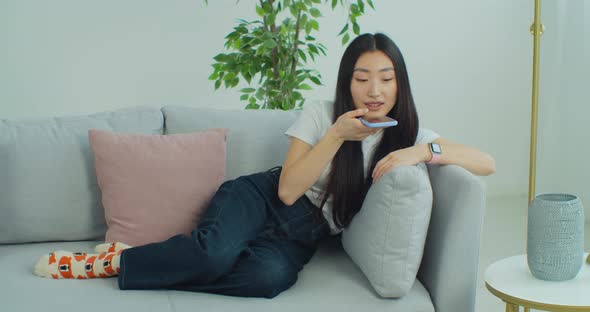 Woman Sending Voice Message Using Mobile Phone alt