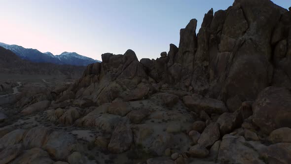 Aerial birds-eye view shot of a young man backpacker camping with his dog in a mountainous desert. alt