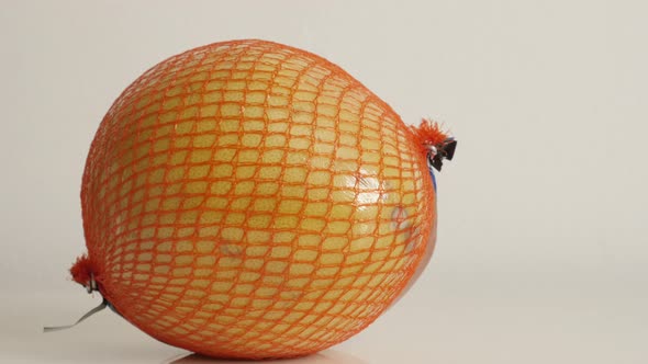 Close-up of exotic pomello fruit packed on white background 4K 2160p 30fps UltraHD footage - Juicy C alt