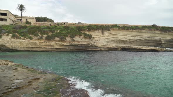 Turquoise Colour Water Stone Beach Il-Kalanka in Malta with Limestone Shore