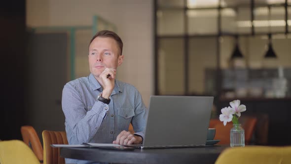 Thoughtful Serious Young Man Student Writer Sit at Home Office Desk with Laptop Thinking of alt