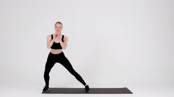 Athletic Young Female in Sportswear Making Side Lunges Exercise in Studio alt