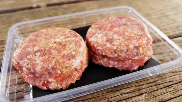 Meat patty in plastic container alt