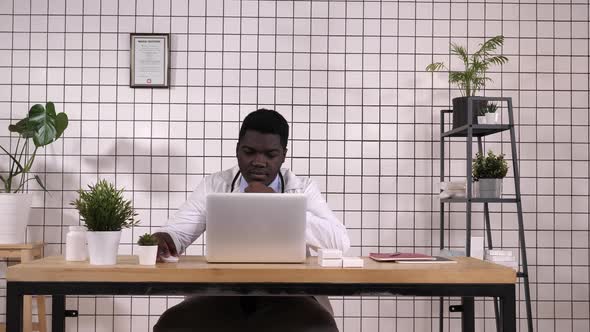 Young African American Doctor at Work, with Laptop alt