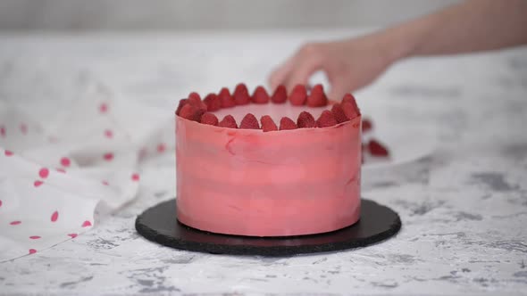 Woman Hands Placing a Raspberries Onto Freshly Cooked Cake