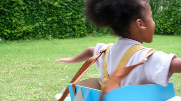 Happy child playing with a toy paper plane in the house. alt