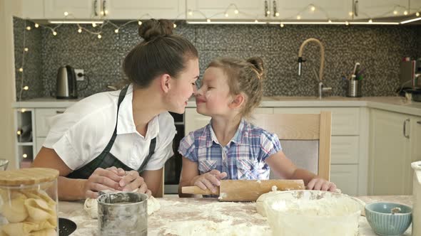 Mom and Little Daughter are Preparing Something in the Kitchen