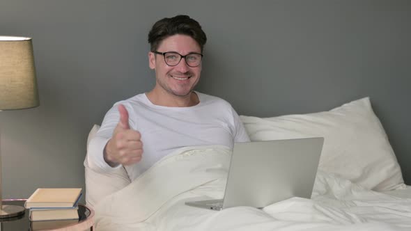 Thumbs Up Sign By Middle Aged Man with Laptop in Bed  alt