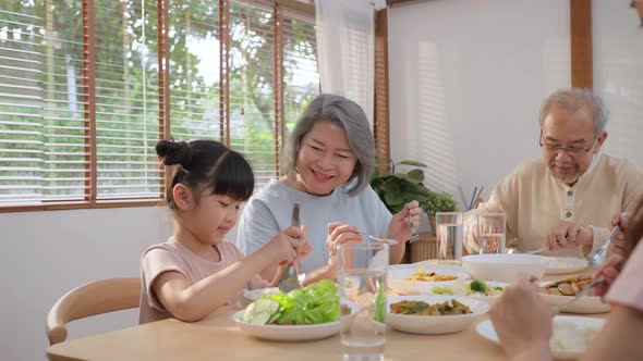 Asian Big happy family spend time have lunch on dinner table with young little kid together at home alt