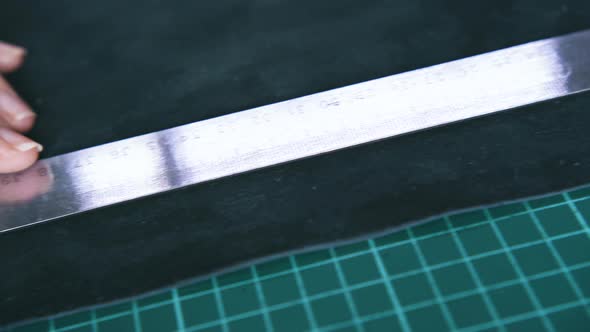 Person Checks Leather Measures on on Cutting Mats Board alt
