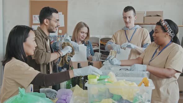 People Sorting out Garbage Indoors alt