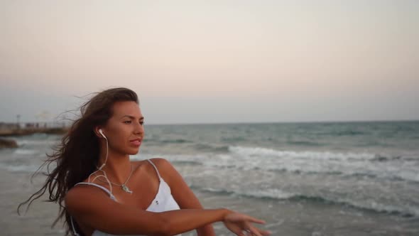 Dancer Listening to Music on Smartphone and Practising at Beach