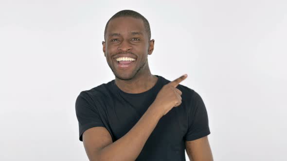 Young African Man Pointing on Side on White Background alt