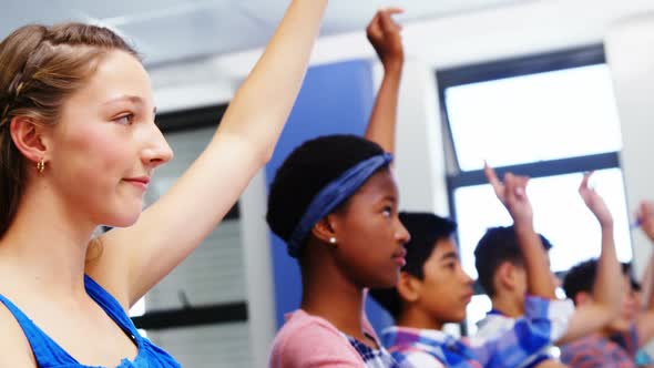 Student raising hand in classroom alt