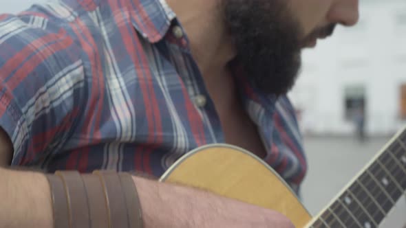 Camera Moves Up From Male Fingers on Guitar Strings To Face of Concentrated Caucasian Man Playing alt