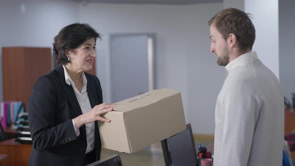 Portrait of Confident CEO Giving Cardboard Box Talking to Fired Employee and Leaving alt