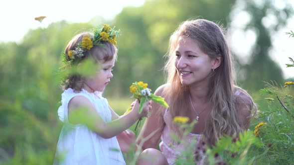 Happy Mother and Daughter with the Flower Wreath
